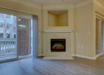 Cozy living room featuring a fireplace with modern finishes at Rose Heights Apartments in Raleigh, NC.