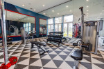 Modern fitness center with gym equipment and large windows in luxury apartment community.