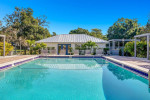 Community pool surrounded by mature landscaping at SoDo Flats apartment complex in Orlando, Florida.