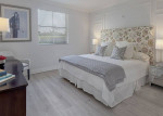 Stylish bedroom in pet-friendly apartment featuring a plush bed, modern decor, and large windows in Coral Gables.