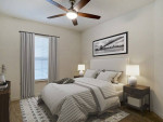 Cozy bedroom featuring a ceiling fan, elegant decor, and bright natural light, ideal for modern apartments.