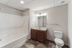 Modern bathroom features a bathtub, vanity with mirror, and tiled flooring in Appleton WI apartment