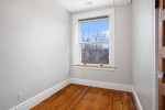 Cozy bedroom in a 2 plus bedroom apartment with hardwood floors and large window.