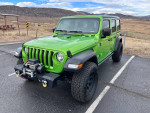 2018 Jeep Wrangler Rubicon 4WD in vibrant green, parked in a scenic outdoor setting