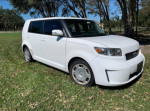 2008 Scion xB hatchback in white with 52,000 miles, parked on grass with trees in background.