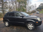 2006 Hyundai Tucson Limited FWD, black SUV with new battery and brakes, in good condition, parked on a scenic road.