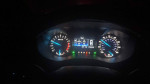 Dashboard of a 2016 Ford Fusion SE showing mileage and gauges in dark lighting.