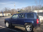 2012 Jeep Patriot 4x4 parked with a large roof rack, clean body and well-maintained interior.