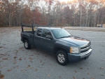 2009 Chevrolet Silverado 1500 LT Extended Cab in a parking lot, showcasing low mileage and rugged design.