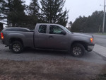 2012 GMC Sierra 4x4 Xtra cab with 58,600 miles parked on a road surrounded by trees.