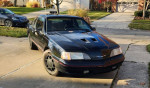 Black Ford car parked outside, showcasing its sleek design and classic style for sale in antique cars category.