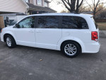 2019 Dodge Grand Caravan SXT minivan with wheelchair lift parked outside a house.