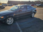 2002 BMW 3 Series 330xi AWD parked, showcasing a sleek black design and alloy wheels.