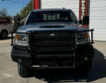 Front view of a GMC Sierra truck with a black grille and rugged design, equipped for towing and off-road performance.