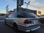 2002 BMW 5 Series 525i Wagon in silver, rear view, showcasing alloy wheels and sunset backdrop.