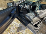 Interior of a 1994 Ford Mustang GT with black leather seats and dashboard details