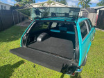Interior view of a 1978 Chevrolet Malibu Wagon with custom teal and black paint, showcasing a spacious trunk.