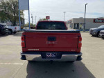 Rear view of a 2014 GMC Sierra 1500 SLE in Fire Red, showcasing the vehicle's sleek design and notable features.