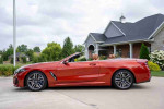 Side view of a 2020 BMW M850i xDrive convertible in Sunset Orange, showcasing its sleek design and upscale detailing.