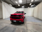 Red Chevrolet Silverado 1500HD Classic front view in a spacious indoor setting