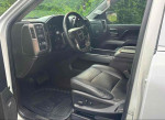 Interior view of a 2014 GMC Sierra 1500 Regular Cab showing black leather seats and dashboard.