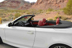 Interior view of a 2013 BMW 135i Convertible with red seats and a scenic background.