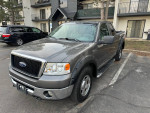 2007 Ford F-150 XLT 4WD pickup truck parked, showcasing its grey exterior and clean condition.