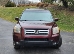 Front view of a 2007 Honda Pilot EX FWD parked on a driveway, showcasing its design and condition.