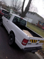 2010 Ford Ranger truck with low mileage parked in a residential area, featuring a clean frame and tires in good condition.