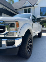 2021 Ford F350 Super Duty Crew Cab in pristine condition with custom wheels and off-road tires.
