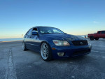 2003 Lexus IS 300 RWD, dark blue sedan with lowered suspension and Enkei wheels parked by the waterfront.