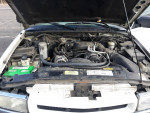 Under the hood of a 1999 Chevrolet TrailBlazer showing engine components and battery.