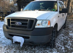 White Ford F150 truck with custom cap, snow plow, and winter tires, gently used and rust-free.
