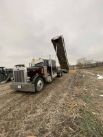 1996 Peterbilt 379 extended hood dump truck with new engine, lifting trailer on a farm road