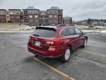 2015 Subaru Outback with new tires parked in a snowy area, showcasing a clean exterior and modern design.