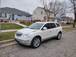 2013 Buick Enclave Limited in white parked on a residential street, showcasing its elegant design and alloy wheels.