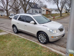 2013 Buick Enclave Limited in silver, parked on a residential street, showcasing its sleek design and chrome wheels.