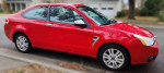 2008 Ford Focus Coupe SE in Vermillion Red with low mileage and excellent condition, parked on the street.