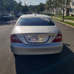 Rear view of a Mercedes-Benz CLS 550 in brilliant silver with a clean and polished look, parked on a residential street.