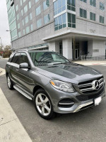 2018 Mercedes-Benz GLE 350 4MATIC SUV parked outside a modern building, showcasing its sleek design and premium features.