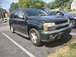 2003 Chevy Trailblazer 4x4 parked in a lot, seats 8, equipped with tow hitch and new tires.