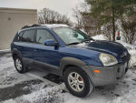 2005 Hyundai Tucson blue SUV with backup camera and Bluetooth, clean interior, on snowy parking lot