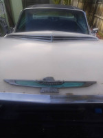 Front view of a classic 1961 Ford Thunderbird showing its emblem and distinctive design features.