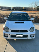 Front view of a 2002 Subaru Impreza WRX in white color, showcasing its sporty design and manual transmission capabilities.