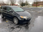 2011 Honda Odyssey EX in black parked, showcasing its sleek design and good condition.