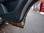 Close-up of the door frame showing rust on a 2010 Mazda CX-9 Grand Touring's interior.