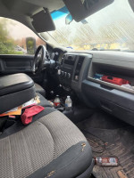 Interior of a 2011 Dodge Ram 3500 diesel 4x4, showing worn seats and cluttered dashboard.