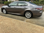 2023 Toyota Camry LE FWD with low mileage and features like Toyota Safety Sense, parked on a driveway.