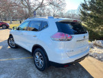 2015 white Nissan Rogue SL parked, showcasing sleek design and modern features.