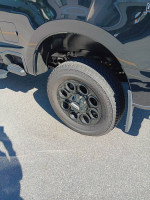 Close-up of a black wheel on a 2023 Ford F-350 Super Duty, showcasing premium design and condition.
